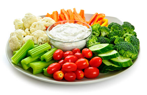 Fresh vegetables arranged on a platter with dip